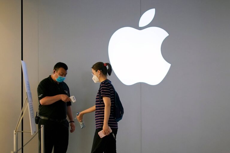 A woman wearing a protective face mask waits to measure her temperature in an Apple Store following the coronavirus disease (COVID-19) outbreak, in Shanghai